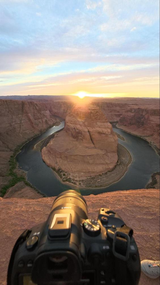 Camera on ledge overlooking Horseshoe Bend at sunset.