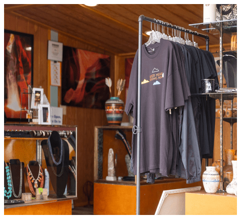 T-shirts and jewelry displayed in a wooden shop interior.
